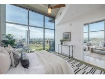 Bright main bedroom with large windows offering city views and stylish decor at 1700 Bassett St # 1106, Denver, CO 80202