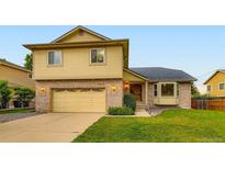 Two-story home with attached garage and manicured lawn at 9670 W 70Th Ave, Arvada, CO 80004