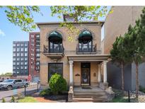 Stunning two-story home with charming balconies, decorative facade, and manicured front yard at 1650 N Pennsylvania St, Denver, CO 80203