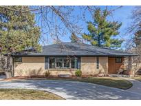 Well-maintained brick ranch-style home featuring updated windows and landscaping on a sunny day at 374 Holly St, Denver, CO 80220