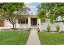 Charming single-story home with a manicured lawn, walkway and lovely landscaping at 415 Forest St, Denver, CO 80220