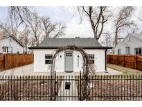 Charming home featuring a white exterior, gray door, and decorative wrought iron fence and gate at 2252 Harlan St, Edgewater, CO 80214