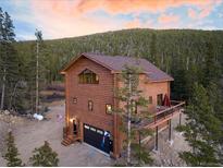 Charming two-story log home with a deck, garage, and views of the surrounding forest at 57 Overlook Ct, Idaho Springs, CO 80452