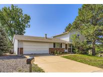 Charming two-story home with a two-car garage and mature trees in a residential neighborhood at 7542 Otis St, Arvada, CO 80003