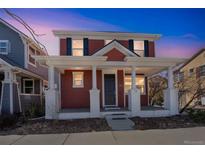 Charming two-story home features a welcoming front porch with stately white columns at 2983 Fulton St, Denver, CO 80238