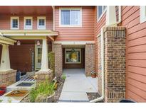 Inviting townhome exterior with brick pillars, covered entrances, and homey welcome decor at 19440 E Mann Creek Dr # E, Parker, CO 80134
