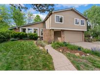 Charming two-story home featuring a well-maintained lawn, beautiful landscaping, and an attached two-car garage at 6621 E Peakview Pl, Centennial, CO 80111