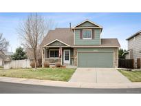 Charming two-story home with a well-manicured lawn and inviting front porch and two-car garage at 11207 Day Star Ct, Parker, CO 80138