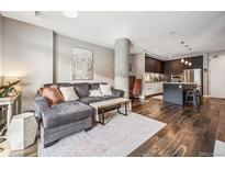 Inviting living room featuring hardwood floors, stylish decor, comfortable seating and an open concept to the kitchen at 4200 W 17Th Ave # 327, Denver, CO 80204