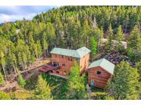 Beautiful wood home nestled in a lush forest with a deck perfect for enjoying nature at 11876 Coal Creek Heights Dr, Golden, CO 80403