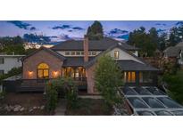 Charming two-story home with a brick exterior, dark roof, a lush garden entrance and manicured landscaping at 375 S University Blvd, Denver, CO 80209