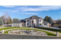 Stunning two-story home with a grand entrance, circular driveway, and meticulously landscaped front yard at 1185 W 140Th Dr, Westminster, CO 80023