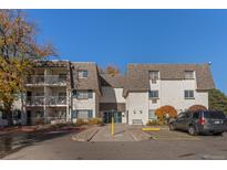 Inviting multi-story condo building featuring white siding, a new roof, private balconies, and ample parking at 5995 E Iliff Ave # 317, Denver, CO 80222