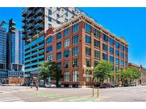 Brick building featuring large windows and streetscape with pedestrian crossing on a clear blue day at 2000 Arapahoe St # 503, Denver, CO 80205
