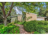 Charming brick home featuring a lush garden and a welcoming brick walkway at 9113 E Evans Way, Denver, CO 80231