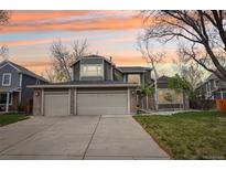 Charming two-story home with a three-car garage and beautifully landscaped front yard against a colorful sunset sky at 13071 Emerson St, Thornton, CO 80241