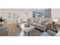 Bright living room featuring modern decor, large windows and stylish, comfortable seating and light colored walls at 4455 S Delaware St, Englewood, CO 80110