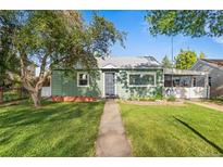 Charming single-story home features a well-manicured lawn, mature trees, and inviting walkway to the front door at 7550 Stuart St, Westminster, CO 80030