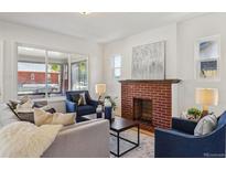 Comfortable living room with a brick fireplace, plush seating, and an open floor plan at 3527 W 44Th Ave, Denver, CO 80211