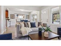 Cozy living room with a comfortable couch, white walls, and view to the dining room at 3527 W 44Th Ave, Denver, CO 80211