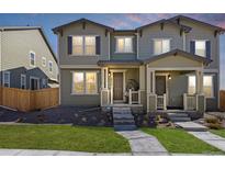 Charming townhome with gray siding, well-manicured lawn, and welcoming front porch, located in a desirable neighborhood at 28334 E 6Th Pl, Watkins, CO 80137