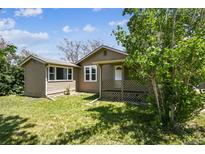 Charming single-story home with a covered front porch and well-maintained lawn at 180 S Lamar St, Lakewood, CO 80226