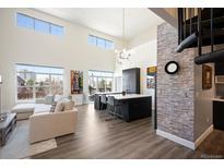 Bright and spacious living room featuring large windows, hardwood floors, modern lighting, and a stylish kitchen island at 5677 S Park Pl # B310, Englewood, CO 80111