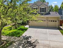 Charming two-story home featuring a well-manicured lawn, mature trees, and an attached two car garage at 6310 W Sumac Ave, Littleton, CO 80123