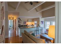 Inviting living room flows into a kitchen featuring an island with barstool seating and hardwood floors at 1435 Vine St # 5, Denver, CO 80206