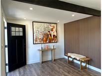 Inviting foyer featuring wood floors, contemporary decor, and an eye-catching accent wall at 1285 Roslyn St, Denver, CO 80220