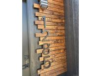 Modern home address numbers in dark bronze against a wood plank panel accent near a gray front door at 1285 Roslyn St, Denver, CO 80220