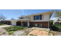 Two-story home with white siding, brick accents, and a covered front porch on a sunny day at 8389 Benton Way, Arvada, CO 80003