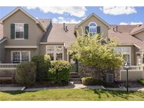 Charming townhome featuring stone accents, landscaped front yard, and a welcoming facade at 10183 Grove Loop # D, Westminster, CO 80031