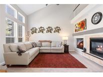 Bright living room featuring a fireplace, high ceilings, large windows and comfortable seating, perfect for relaxing and entertaining at 10183 Grove Loop # D, Westminster, CO 80031