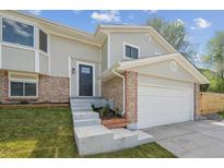Charming gray two-story home featuring brick accents, fresh landscaping, and a convenient two-car garage at 3247 S Newland St, Denver, CO 80227