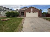 Charming brick home with a well-manicured front yard and a two-car garage at 11304 Niagara St, Thornton, CO 80233