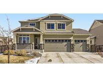 Charming two-story home with a three-car garage, stone accents, and inviting front porch at 296 N Newcastle Way, Aurora, CO 80018