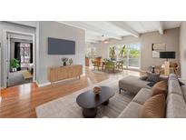 Cozy living room features hardwood floors, large TV, and flows into dining area with outdoor access at 1441 N Humboldt St # 204, Denver, CO 80218
