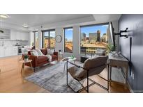Bright living room featuring hardwood floors, large windows showcasing city views, and comfortable contemporary furniture at 1750 Wewatta St # 830, Denver, CO 80202