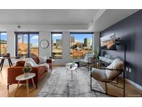 Inviting living room with expansive windows offering stunning city views and modern furnishings at 1750 Wewatta St # 830, Denver, CO 80202