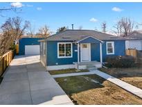 Charming blue home boasts a welcoming entryway and a spacious driveway leading to a detached garage at 2826 W Park Pl, Denver, CO 80219