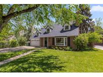 Charming brick home with lush front yard and well-maintained landscaping, driveway and garage at 400 Holly St, Denver, CO 80220