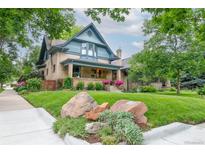 Charming two-story brick home with a beautifully landscaped front yard and inviting front porch at 3701 Eliot St, Denver, CO 80211