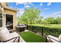 Inviting back patio with grill, chairs, and lush greenery, ideal for outdoor relaxation and entertaining at 22391 E Plymouth Cir, Aurora, CO 80016
