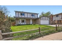 Charming two-story home featuring stone accents, a well-manicured lawn, and a welcoming two-car garage at 8897 Wagner Ln, Westminster, CO 80031