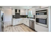 Modern kitchen with white cabinets, stainless steel appliances, and a stylish backsplash, providing a sleek design at 8897 Wagner Ln, Westminster, CO 80031