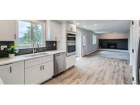 Bright kitchen boasts stainless steel appliances, dark backsplash and adjacent living area at 8897 Wagner Ln, Westminster, CO 80031