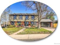 Charming two-story home with red brick accents, a large tree, and a glass garage door at 3766 E Easter S Cir, Centennial, CO 80122