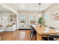 Light-filled dining area featuring hardwood floors and a modern pendant light at 4511 Bryant St, Denver, CO 80211