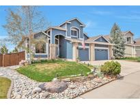 Charming two-story home with a lush front yard and a welcoming two-car garage at 9371 Desert Willow Trl, Highlands Ranch, CO 80129